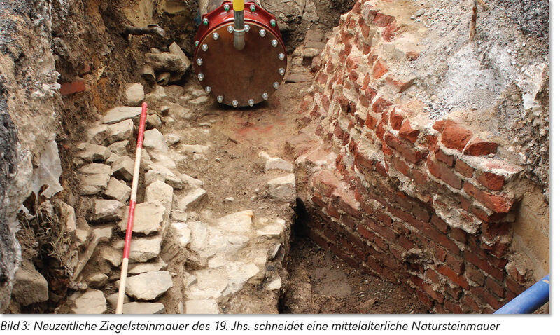 Neuzeitliche Ziegelsteinmauer des 19. Jahrhunderts schneidet eine mittelalterliche Natursteinmauer.