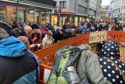 Menschen schauen bei einer Führung in eine Baugrube